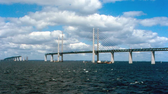 Le pont de l’Øresund en construction en 1999 : pylônes et poutre en treillis sont en place, une grue travaille encore sur un pylône.