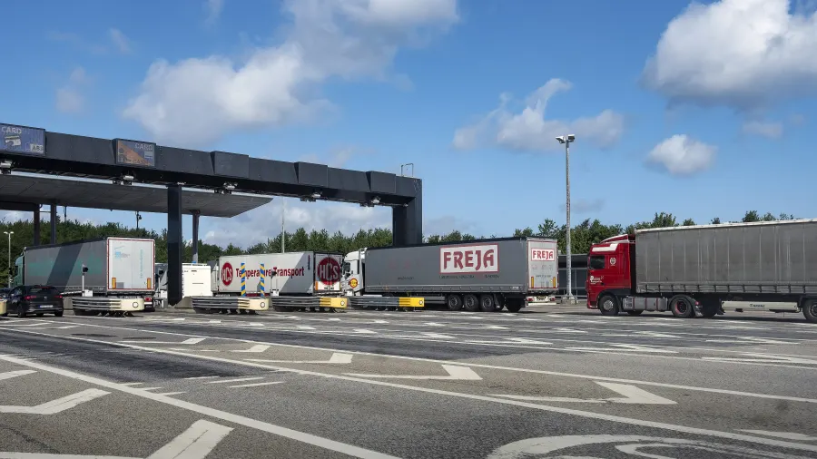 Vrachtwagencombinaties bij het tolplein Lernacken, daarachter de overkapping van de betaalstroken.